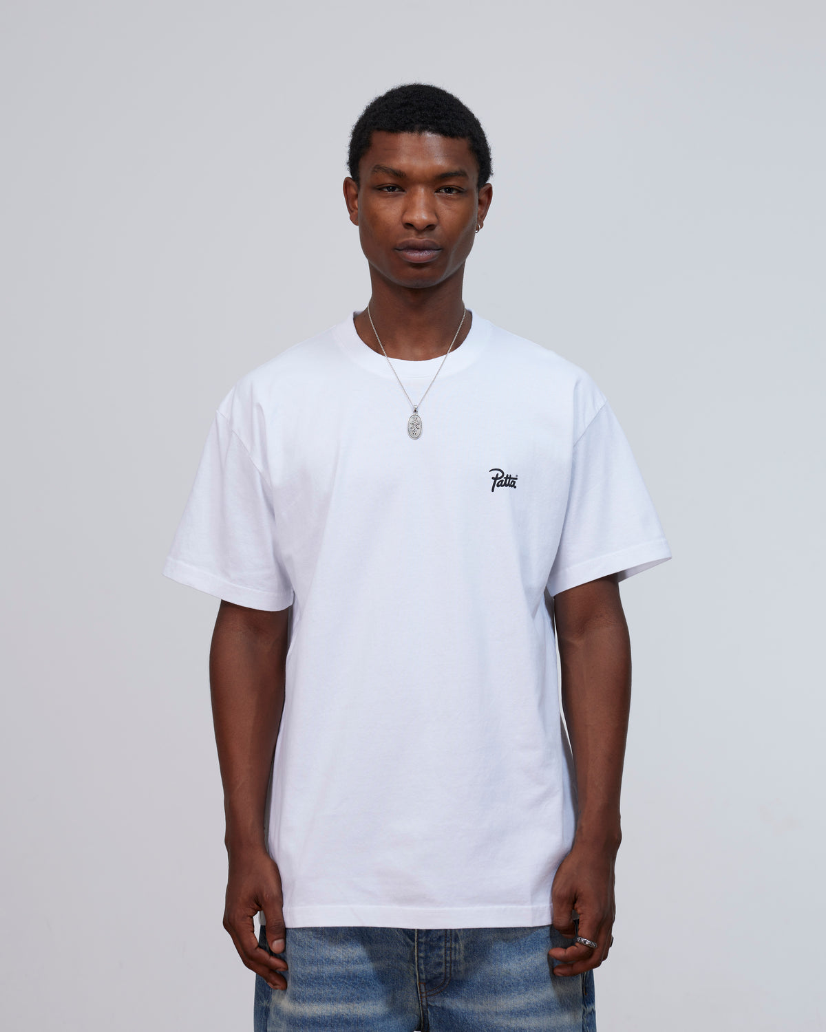Model wearing the white Patta Championship T-shirt featuring a script logo on the chest.
